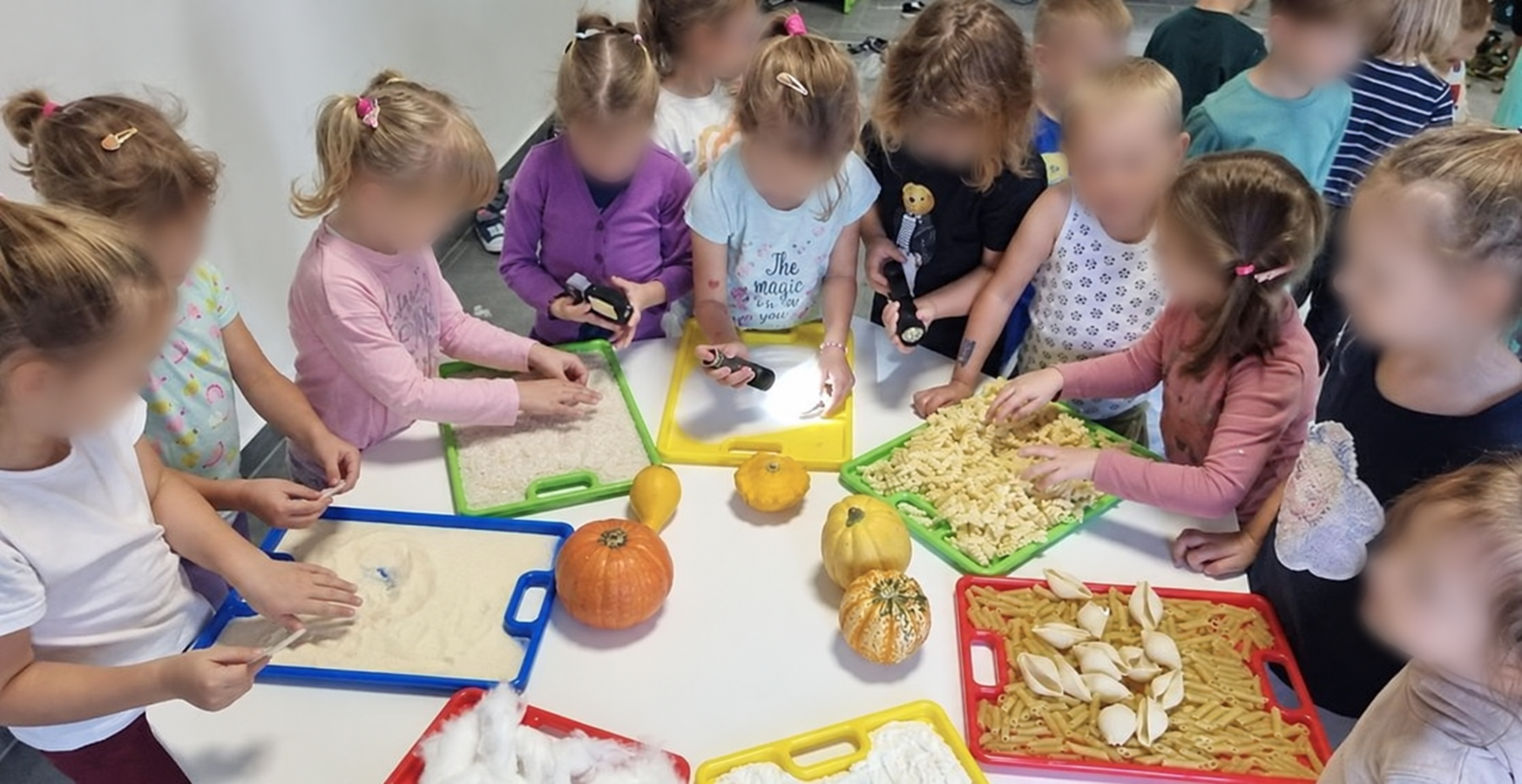 Dzieci podczas jesiennych zajęć sensorycznych; twarze zamazane dla ochrony prywatności